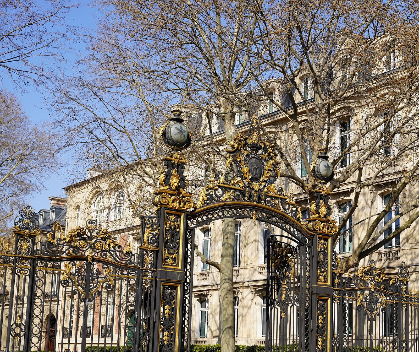 Grille noir et or du parc Monceau devant des immeubles haussmanniens
